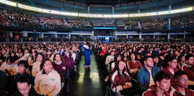 Vista panorámica del Movistar Arena de Bogotá lleno de estudiantes durante Biz Fest 2025. En primer plano, cientos de jóvenes de colegios de Puente Aranda y otras localidades escuchan atentos, mientras en las graderías se aprecia la masiva asistencia al evento. Una pantalla en la parte superior muestra el lema “Sueña en grande”, resaltando el espíritu de inspiración y emprendimiento juvenil del festival.