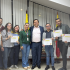 “Grupo de personas posando en un salón de la Alcaldía Local de Puente Aranda luego del acto de posesión del Consejo Local LGBTI 2026–2027. Varias de ellas sostienen certificados en las manos. En el centro se encuentra un funcionario de la Alcaldía acompañado por integrantes electos del Consejo. Al fondo se observan las banderas de Bogotá y de Colombia, y en las esquinas superiores aparecen los logos institucionales de ‘Bogotá’ y de la Alcaldía Local de Puente Aranda.”
