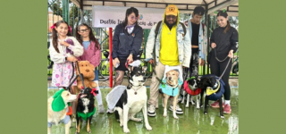 Un grupo de personas posa junto a sus perros disfrazados durante el Desfile interespecie realizado en el parque El Sol, en Puente Aranda, como parte de la Semana de Protección y Bienestar Animal.